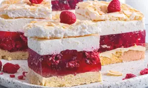 Malinowa chmurka z bezą i malinami. Ile piec bezę do malinowej chmurki? Warstwy biszkoptu, galaretki z malinami, kremu i bezy ze płatkami migdałów.