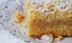 Pyszna szarlotka na kruchym cieście, posypana cukrem pudrem. Idealna na podwieczorek, zastanawiasz się, ile się piecze szarlotkę na kruchym cieście?