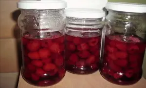 Trzy słoiki pełne soczystych malin w soku własnym, gotowe na zimę.