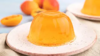 Pomarańczowa galaretka na talerzyku, obok morele. Jak uratować galaretkę, która nie stężała? Dodaj żelatynę!