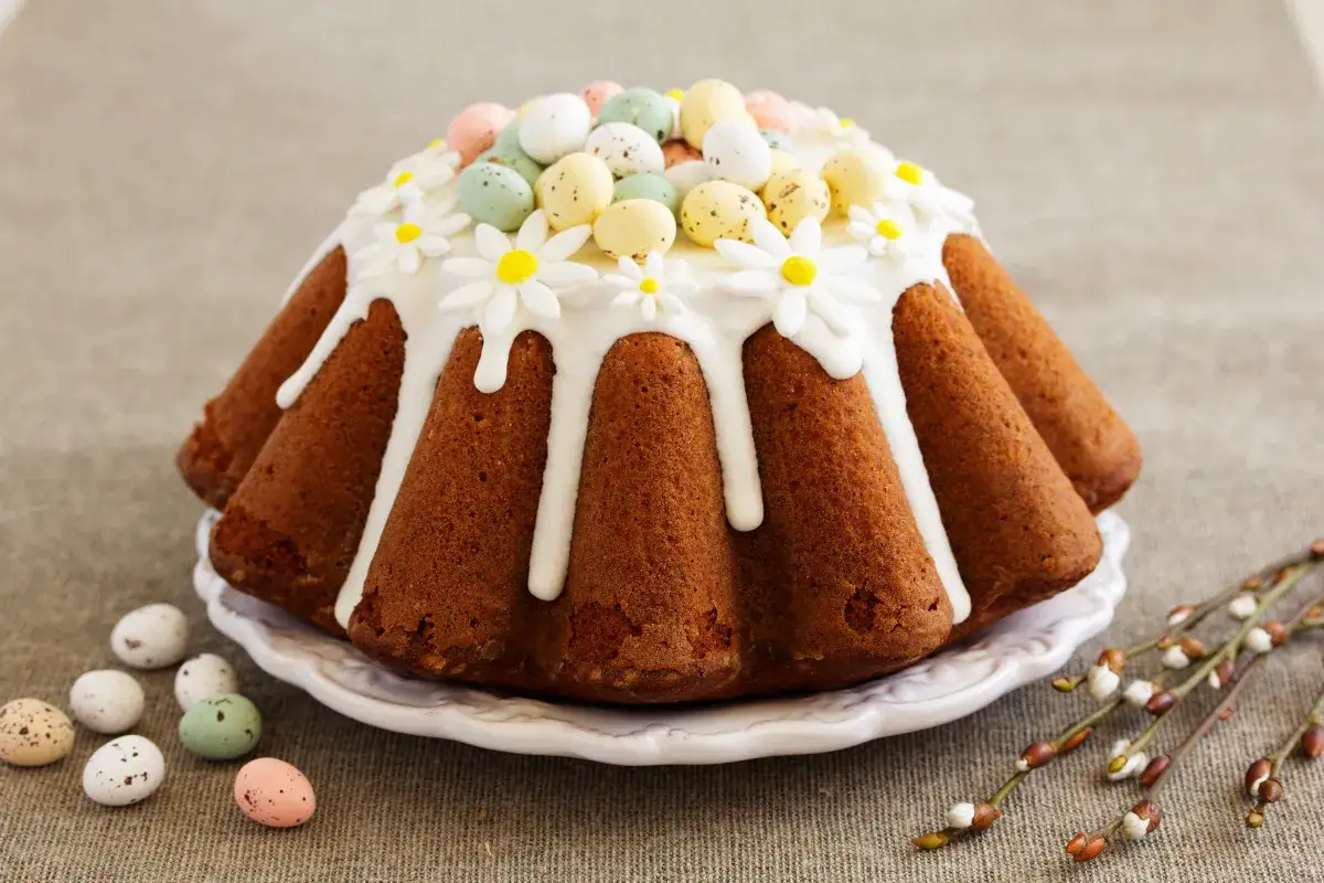Babka wielkanocna przepis: puszysta babka z lukrem, ozdobiona cukrowymi kwiatkami i kolorowymi jajeczkami. Idealna na święta!