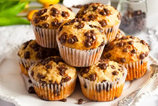 Stos muffinek bananowo czekoladowych, pachnących domem i słodyczą, gotowych do zjedzenia.